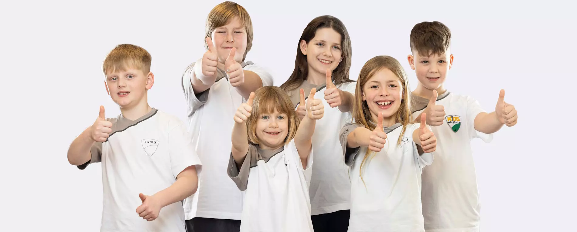 EWTO Kids WingTsun Vorarlberg – sechs Kinder in Trainingsshirts zeigen lachend den Daumen nach oben